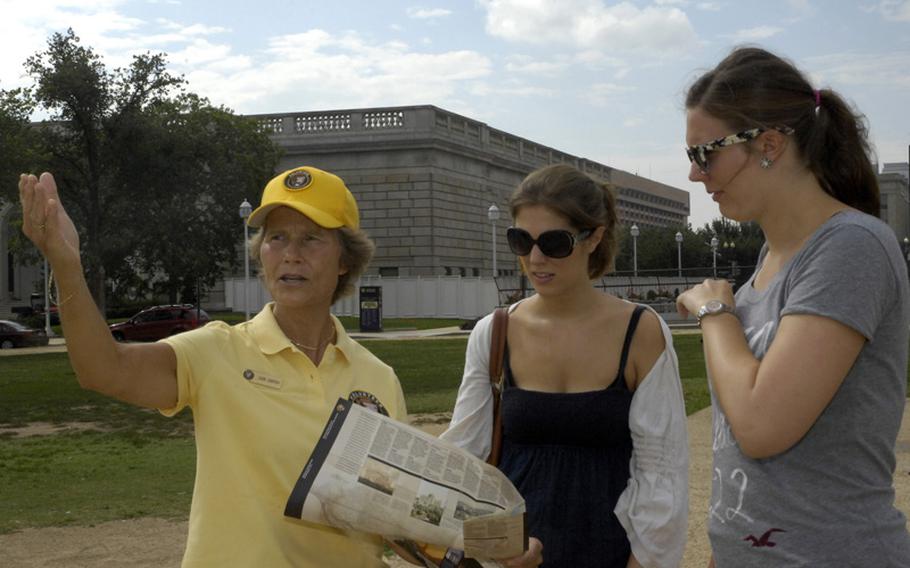 Joan Darrah, a retired Navy captain and a volunteer roving docent, assists tourists in need of direction and information on the National Mall in Washington, D.C. 