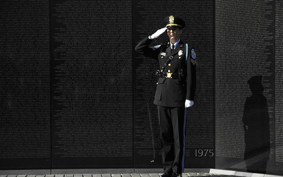 A police officer salutes during a wreath-laying ceremony at the Vietnam Veterans Memorial wall on Veterans Day, Nov. 11, 2012.