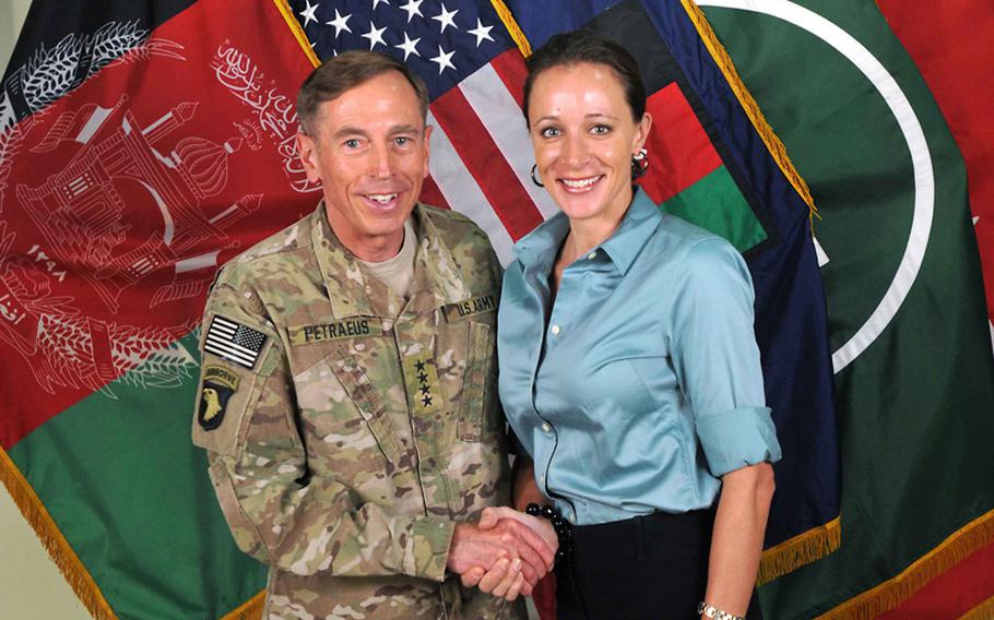 This July 13, 2011, photo made available on the International Security Assistance Force's Flickr website shows the former Commander of ISAF and U.S. Forces-Afghanistan Gen. David Petraeus, left, shaking hands with his biographer Paula Broadwell, with whom he had an extramarital affair.