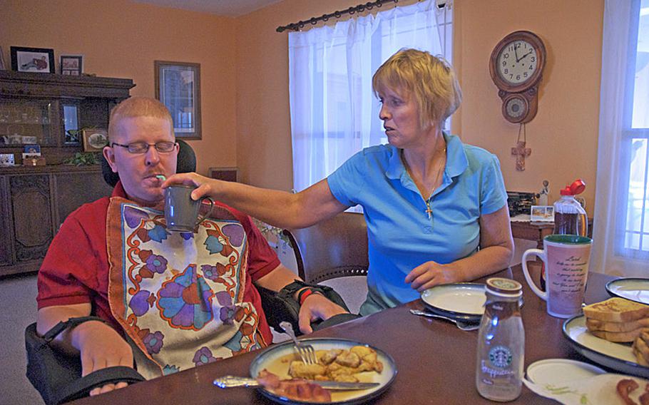 On a Saturday morning in June of 2012, Christine Schei's plate remains empty while she feeds her 28-year-old son, Erik, breakfast. Erik was shot in the head in Iraq in 2005 and has little use of his body.