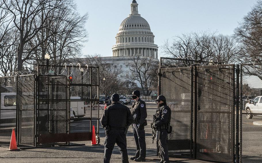 Capitol Police officers stand at an entry point through fencing that surrounds the Capitol complex on March 3, 2021.