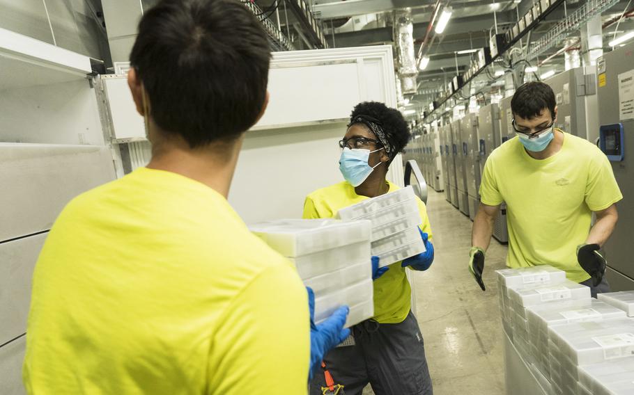 Pfizer freeze operation technicians load vaccine doses into a freezer at the Kalamazoo facility. MUST 