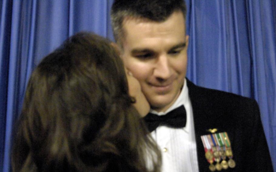 Navy Lt. Cmdr. Mike Greentree gets a kiss from his wife, Vivian.