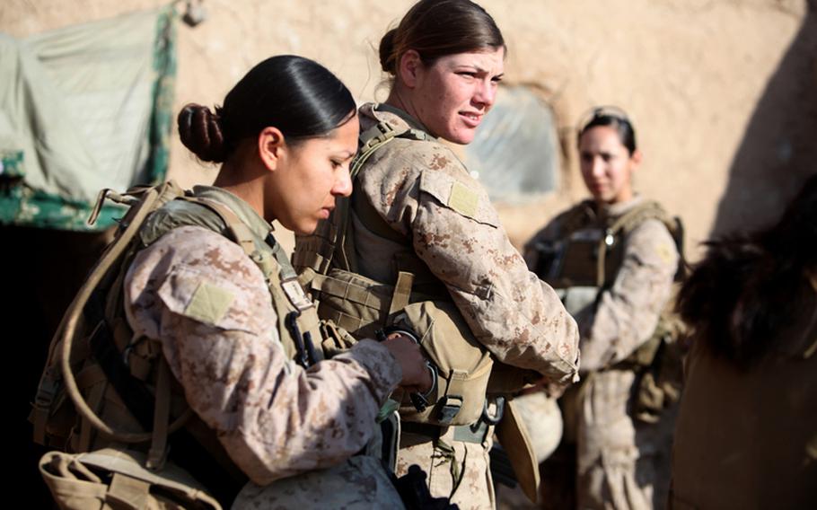 Female Marines assigned to an engagement team speak with a villager in the Helmand province of Afghanistan, Dec. 30, 2010.