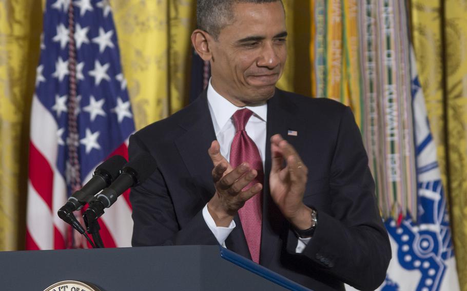 President Barack Obama leads the applause for veterans who were imprisoned in Korea with Father Emil Kapaun during a Medal of Honor ceremony for Kapaun at the White House on April 11, 2013.
