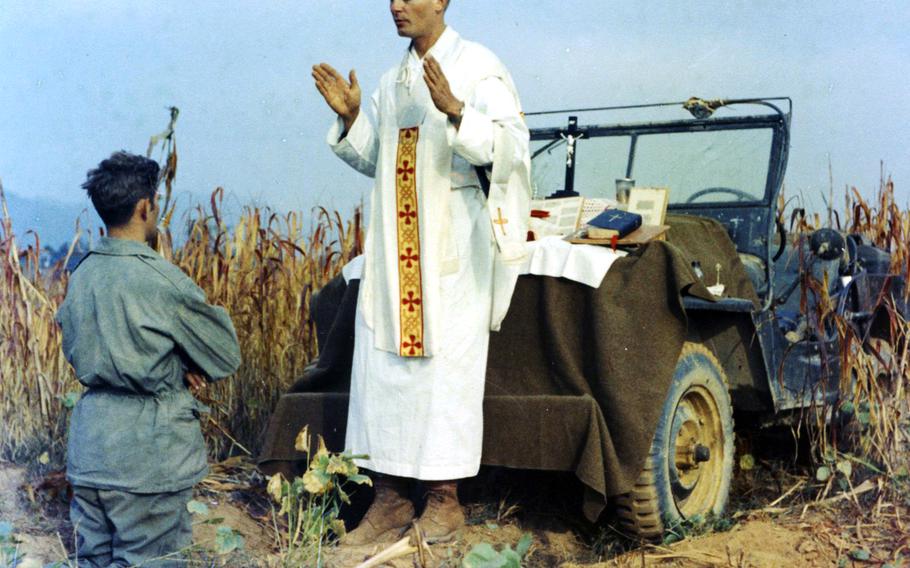 In this photo taken October 7, 1950, less than a month before he was taken prisoner, Kapaun celebrates Mass using the hood of his jeep as an altar. Kneeling is Kapaun's assistant, Patrick J. Schuler, who was with him the night he was captured.