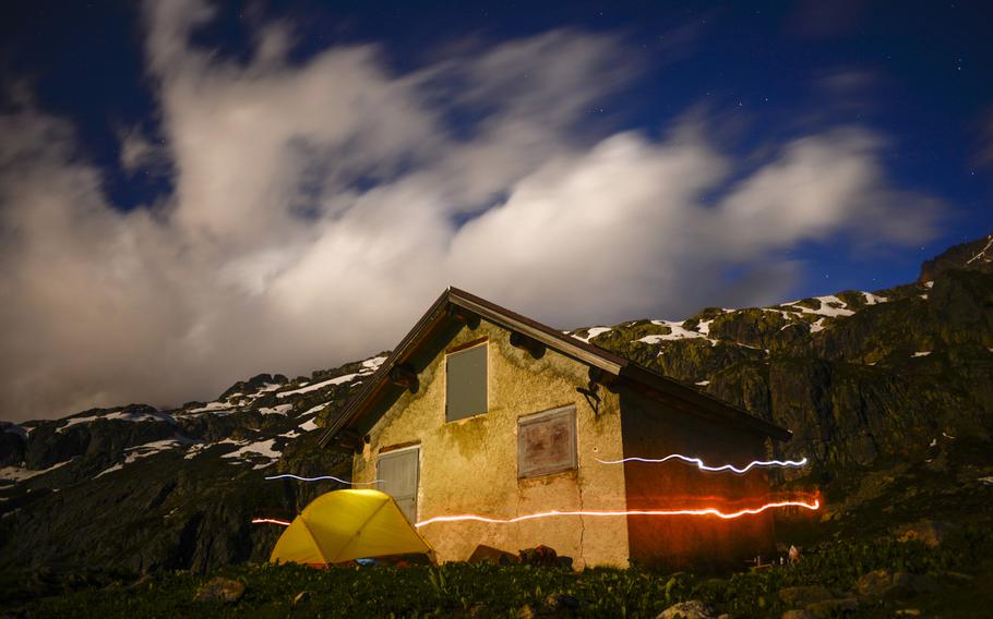 Matt Millham's, a Stars and Stripes reporter, headlight and lamp streak by a camping site in front of the Chalet des Cheserys along a piece of the Tour du Mont Blanc hiking trail above the Chamonix Valley, France.

