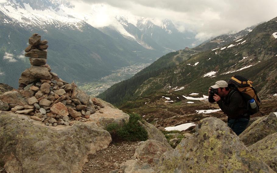 Joshua L. DeMotts, a Stars and Stripes photographer, photographs a man-made pile of rocks known as cairns along the Tour du Mont Blanc during an overnight hiking trip above the Chamonix Valley, France.
