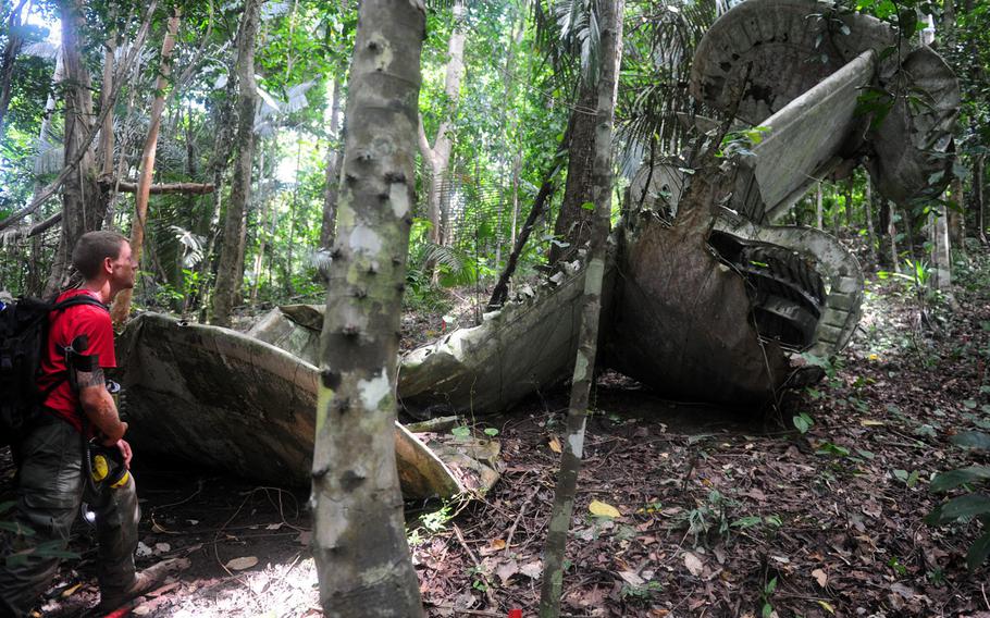 A member of a a JPAC recovery team observes wreckage from a B-24 Liberator during excavation operations in Madang Province in Papua New Guinea in this 2008 photo.