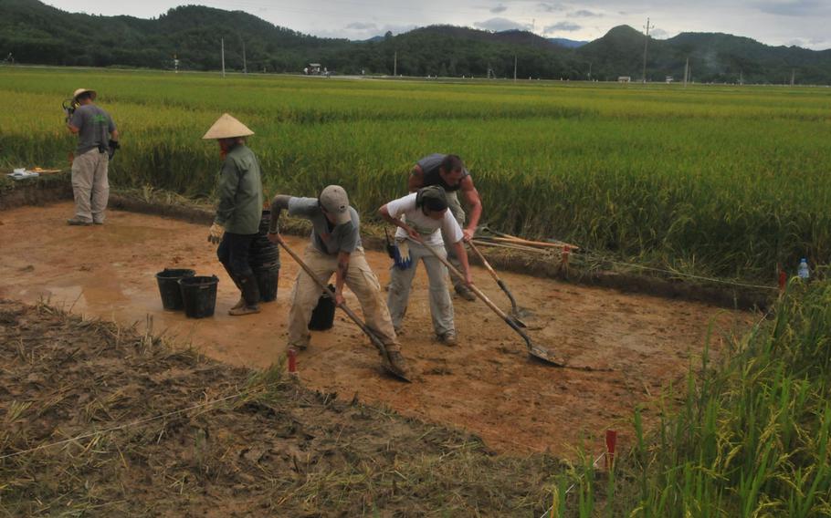 Recovery members from Joint POW/ MIA Accounting Command (JPAC) use shovels to collect dirt to be screened for possible remains at an excavation site in Ha Tinh province, Socialist Republic of Vietnam in this Aug. 2010 photo.