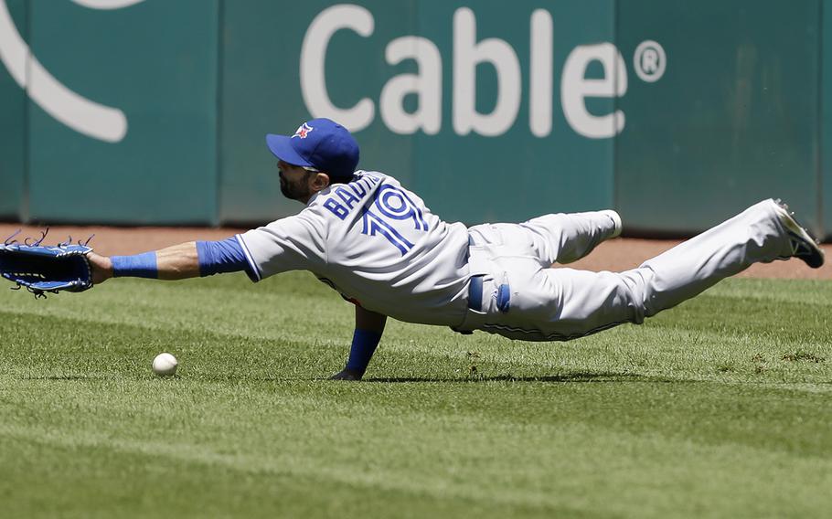 Toronto Blue Jays right fielder Jose Bautista dives for an rbi triple hit by Cleveland Indians' Carlos Santana in the eighth inning of a baseball game, Thursday, July 11, 2013, in Cleveland. The Indians won 4-2. (AP Photo/Tony Dejak)