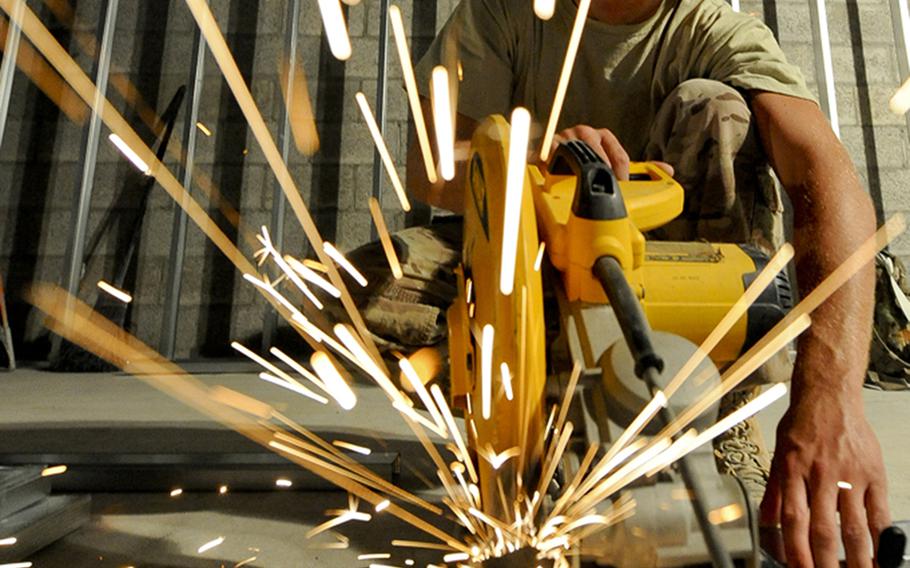 U.S. Air Force Staff Sgt. Eric MacDonald, 557th Expeditionary Red Horse Squadron structures journeyman, cuts wall frame beams to size in Southwest Asia, on July 31, 2013.