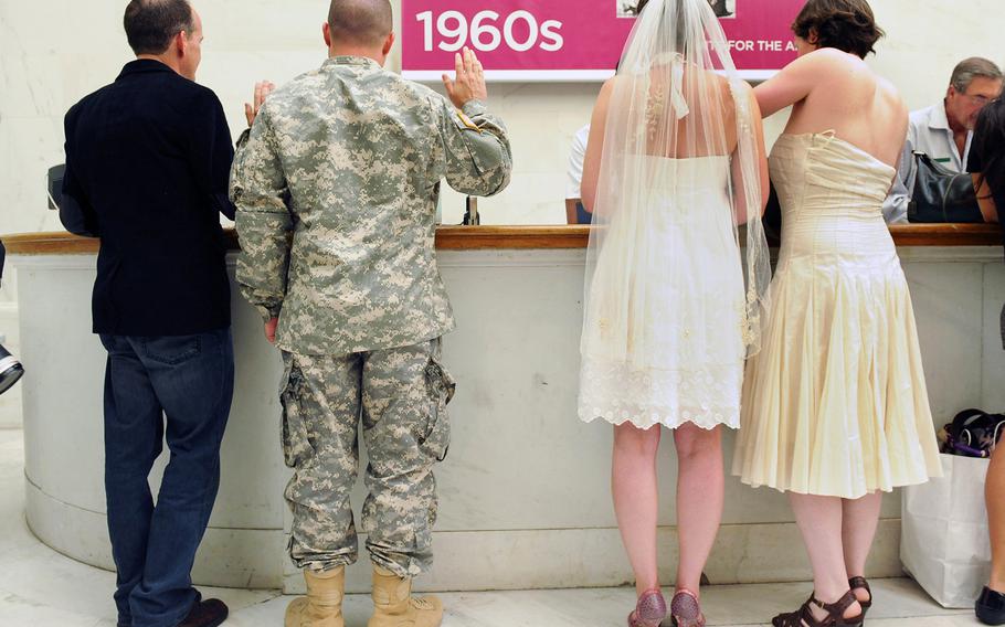 Army Sgt. Michael Potoczniak and his partner, Todd Saunders, left, and Cynthia Wides, left, and Elizabeth Carey go through the process of getting married at City Hall in San Francisco, California,  June 29, 2013.