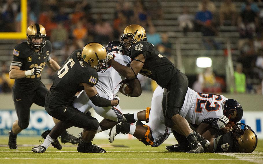 Two Army defenders team up for a tackle during their 28-12 victory over visiting Morgan State Aug. 30, 2013, at Michie Stadium. 