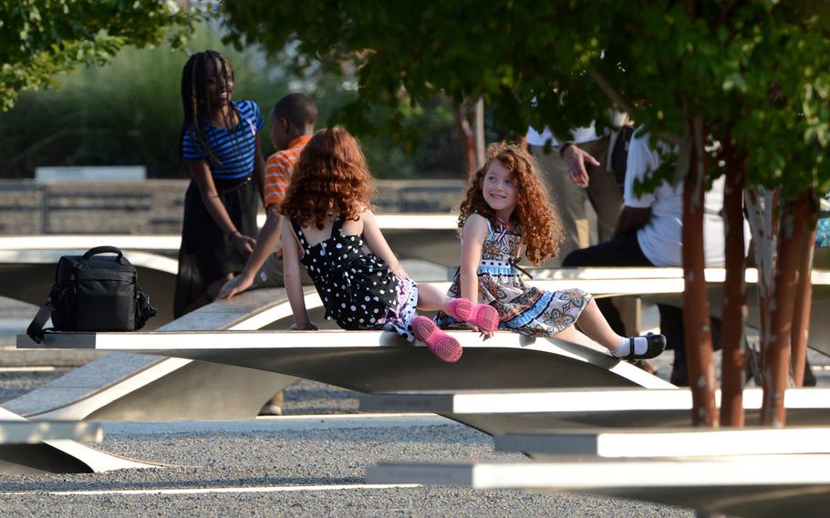 Children rest on the benches of the Pentagon Memorial at the Pentagon in Arlington, Virginia, Wednesday, September 11, 2013. There are 184 benches in the Pentagon Memorial representing the 184 people who died at the Pentagon on September 11, 2001. 