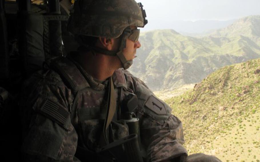 Capt. William Swenson looks out at the rough terrain of eastern Afghanistan from a Black Hawk helicopter.