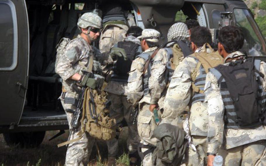 Capt. William Swenson leads Afghan Border Police members as they board a UH-60 Black Hawk helicopter in May 2009.