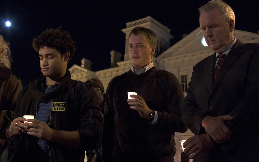 D.C. Councilmember Tommy Wells, far right, bows his head during a moment of silence on Sept. 17, 2013. He was part of a small crowd that gathered to honor the victims of the Navy Yard shooting.