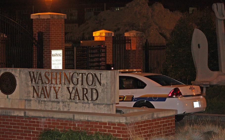 A police car is parked outside the Navy Yard gates and across from a makeshift memorial on Sept. 17, 2013.