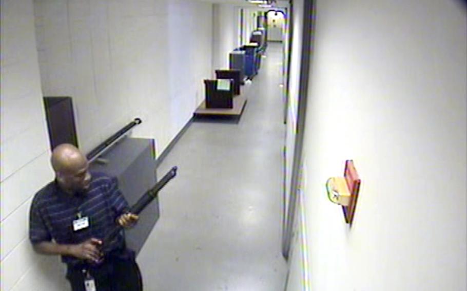 This image from video provided by the FBI, shows Aaron Alexis moves through the hallways of Building #197 at the Washington Navy Yard on Monday, Sept. 16, 2013, in Washington, carrying a Remington 870 shotgun. Alexis, a 34-year-old former Navy reservist and IT contractor, shot and killed 12 people inside a Navy Yard building last week before being killed in a shootout with police.