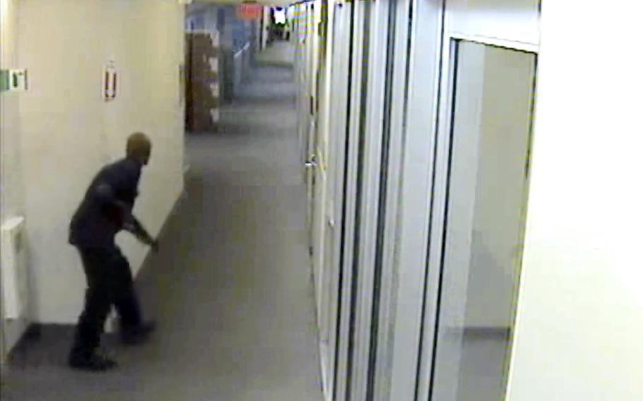 This image from video provided by the FBI, shows Aaron Alexis moves through the hallways of Building #197 at the Washington Navy Yard on Monday, Sept. 16, 2013, in Washington, carrying a Remington 870 shotgun. Alexis, a 34-year-old former Navy reservist and IT contractor, shot and killed 12 people inside a Navy Yard building last week before being killed in a shootout with police.