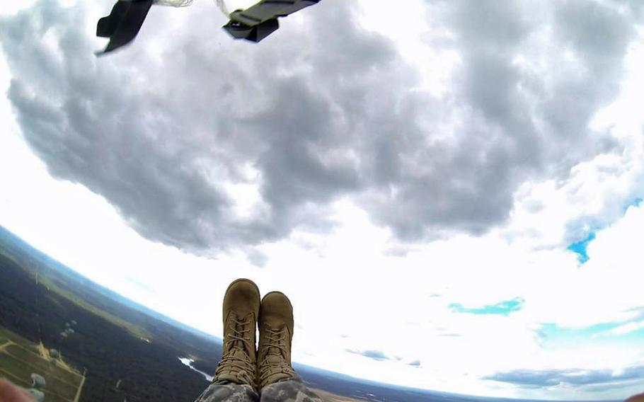 A paratrooper with the 82nd Airborne Division's 1st Brigade Combat Team clutches her reserve parachute and keeps her feet and knees together while her T-11 parachute inflates over Luzon Drop Zone, Sept. 27, on Fort Bragg, N.C. Paratroopers from throughout the 82nd Abn. Div. participated in cultural exchange jumps with jumpmasters from the Brazilian army. (U.S. Army photo by Staff Sgt. Mary S. Katzenberger)