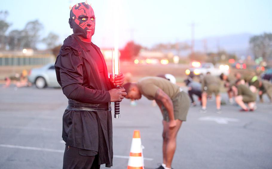 A Marine with Headquarters Company, Combat Logistics Regiment 17, 1st Marine Logistics Group, leads a physical training station during a Halloween-themed PT circuit conducted aboard Camp Pendleton, Calif., Oct. 30, 2013. The Marines wore Halloween costumes and held a festive costume competition at the end of the exercise to build unit cohesion, and provide them an opportunity to unwind and have fun with their peers.