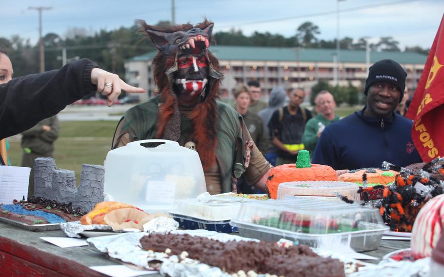 Sgt. Maj. Dennis Downing, Marine Wing Support Squadron (MWSS) 272 sergeant major, auctions off cakes made by each individual company within the squadron as part of the Halloween event conducted by MWSS-272, Oct. 25.