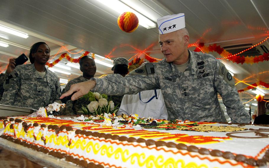 Lt. Gen. James L. Terry, commanding general, U.S. Army Central Command, cuts a cake during Thanksgiving lunch at Camp Buehring in Kuwait.
