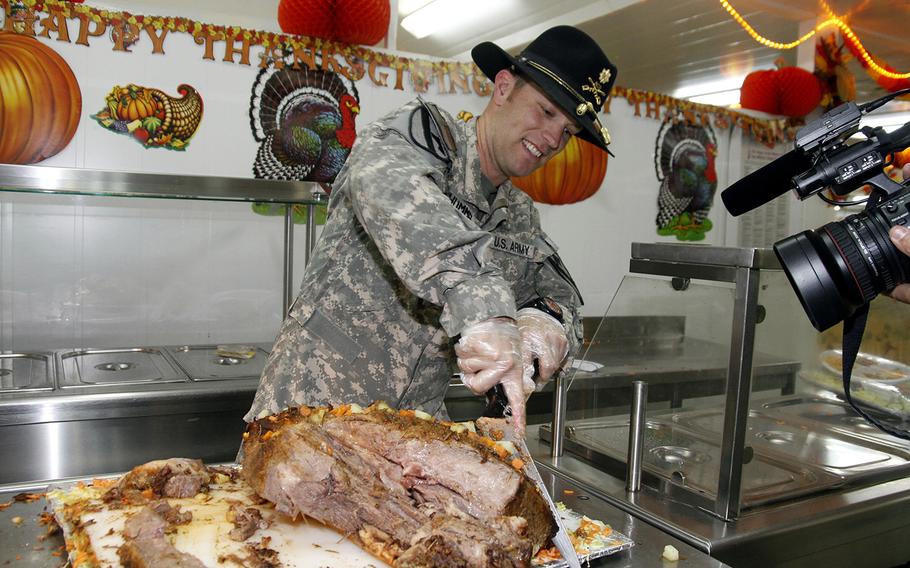 Maj. Brian M. Hummel, executive officer for the 4-227th Attack-Reconnaisance Battalion, 1st Cavalry Division, helps serve Thanksgiving lunch to the Soldiers at Camp Buehring in Kuwait.  