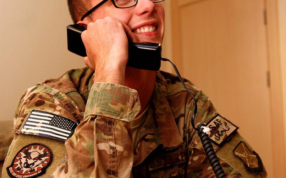 Staff Sgt. Dustin Hawkins, 451st Expeditionary Civil Engineer Squadron, Kandahar Airfield, Afghanistan, talks to President Barack Obama on the phone Nov. 28, 2013. The president thanked Hawkins for his service and talked football with him. Hawkins is deployed from Mountain Home Air Force Base, Idaho. 