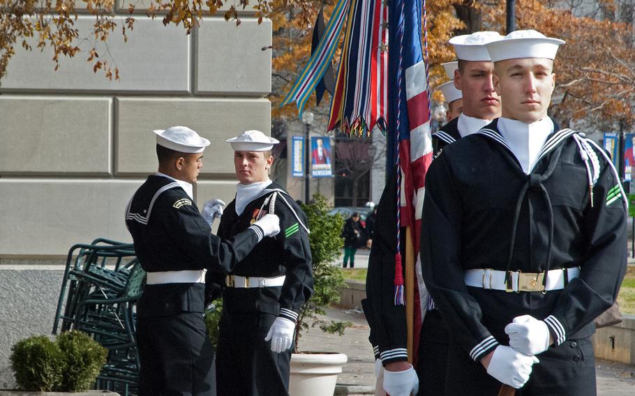 A sailor helps another sailor out before they participate in the Pearl Harbor Remembrance Day at the U.S. Navy Memorial in Washington, D.C. on Dec. 7, 2013.