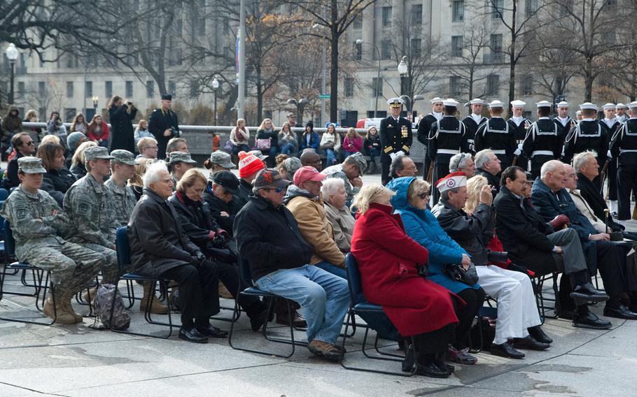 People huddle in their coats during the Pearl Harbor Remembrance Day at the U.S. Navy Memorial in Washington, D.C., on Dec. 7, 2013.