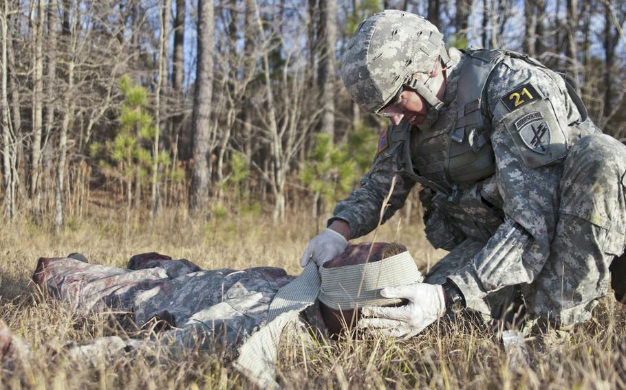 Sergeant First Class Jason Manella performs first aid as part of the Department of the Army Best Warrior Competition in Fort Lee, Va., Nov. 20, 2013