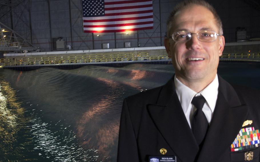 Capt. Rich Blank, commander of the Naval Surface Warfare Center's Carderock Division, stands in front of  the newly-renovated Maneuvering and Seakeeping Basin