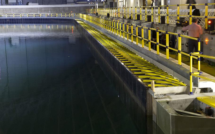 The newly-renovated Maneuvering and Seakeeping Basin at the Naval Surface Warfare Center's Carderock Division in Maryland. The tank, used for testing the performance of ship models, is larger than a football field at 360 feet by 240 feet, and holds 12 million gallons of water. It uses 216 individually-controlled wave boards, at center, to create precise wave environments that weren't possible with the previous pneumatic system.