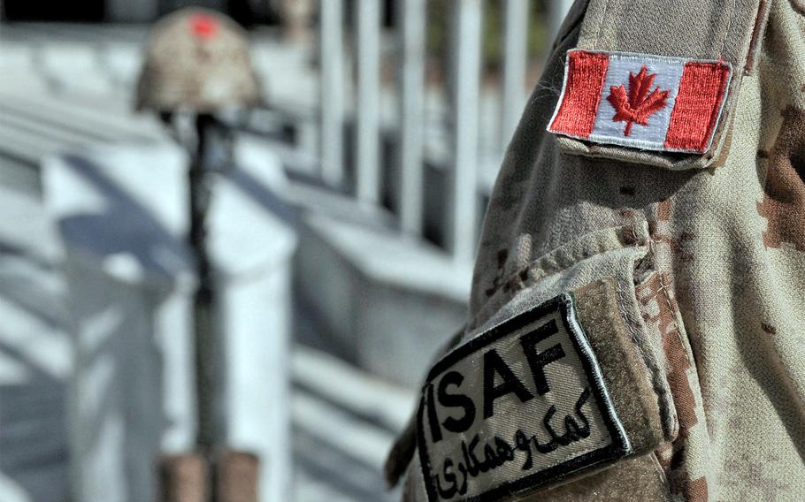 A Canadian soldier renders honors to a battlefield cross in Kabul on Nov. 11, 2013.