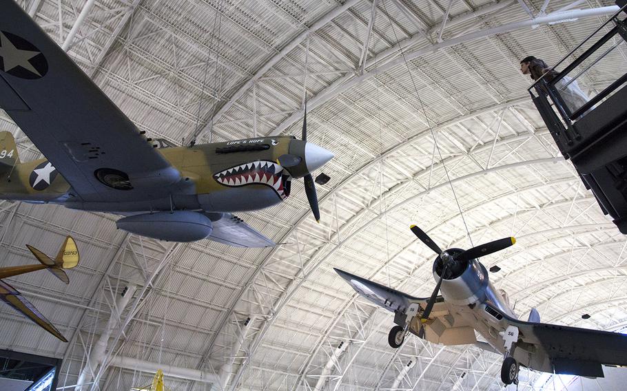 The World War II Curtiss P-40E Kittyhawk, left, and other fighter planes hang from the ceiling at the National Air and Space Museum's Steven F. Udvar-Hazy Center, November, 2013.