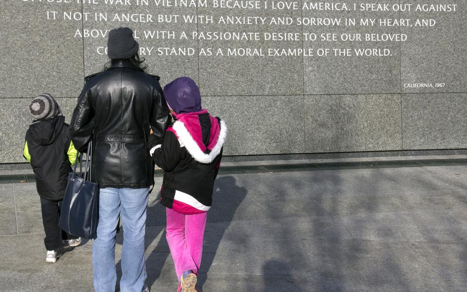 Ayo Winters of Washington, D.C. explains the legacy of Dr. Martin Luther King Jr. to her children Adalia, 9, and Evan. 6, at the Martin Luther King Jr. Memorial on January 20, 2014.