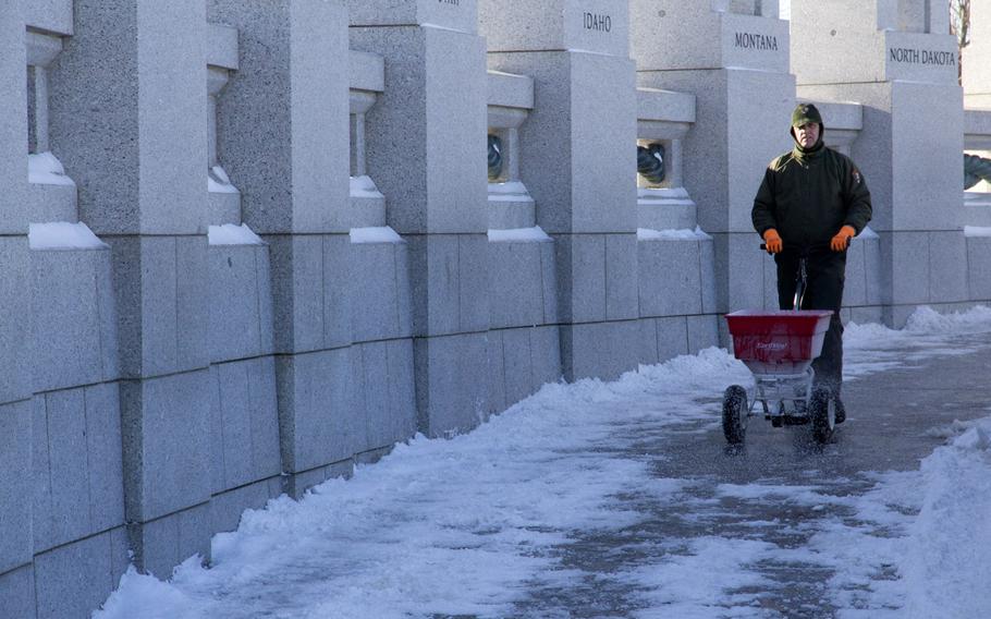 A National Park Service worker clears the path at the National World War II Memorial in Washington, D.C. in the wake of Winter Storm Janus, on January 22, 2014.