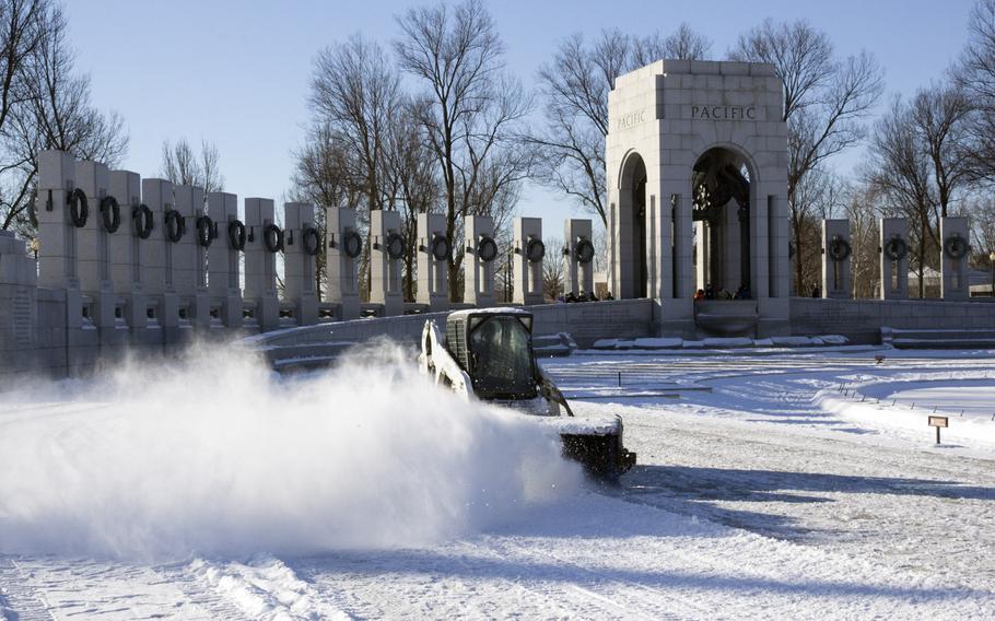 A National Park Service worker clears snow at the National World War II Memorial in Washington, D.C. in the wake of Winter Storm Janus on January 22, 2014.