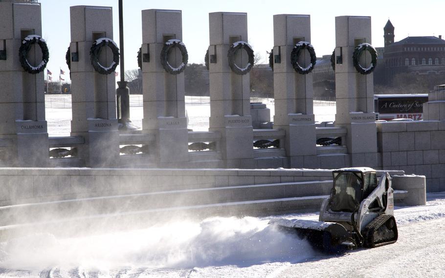 A National Park Service worker clears snow at the National World War II Memorial in Washington, D.C. in the wake of Winter Storm Janus on January 22, 2014.