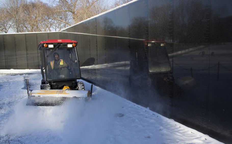 A National Park Service worker clears snow from the path at the Vietnam Veterans Memorial in Washington, D.C. in the wake of Winter Storm Janus on January 22, 2014.