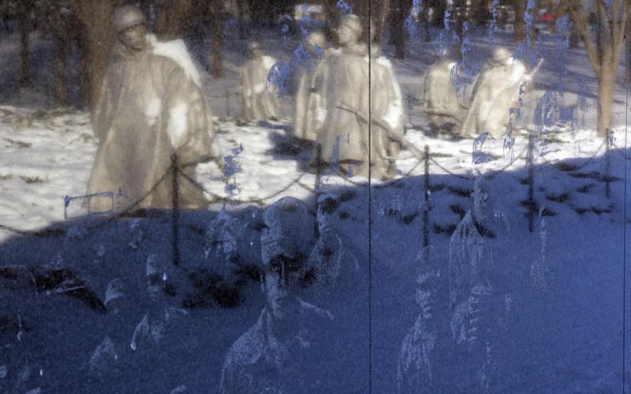 Statues at the snow-covered Korean War Memorial in Washington, D.C., are reflected in the memorial wall in the wake of Winter Storm Janus, on January 22, 2014.