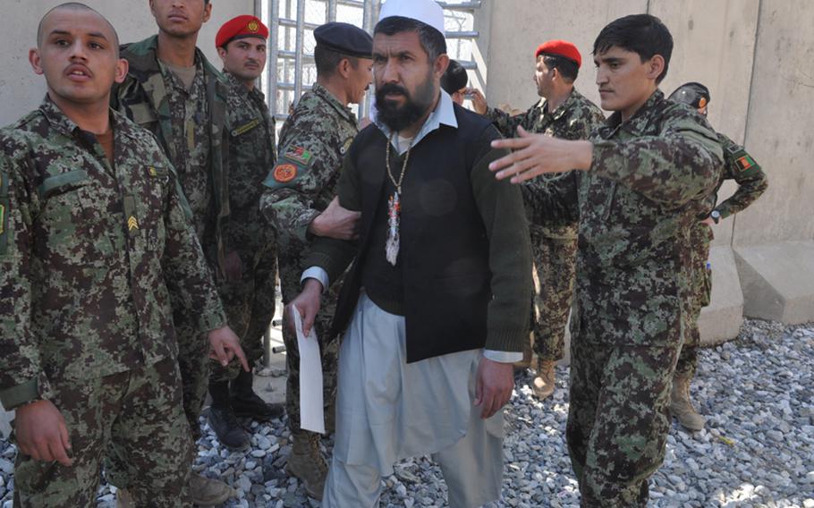 A prisoner is led away after being released as part of a ceremony to mark the handover of Parwan Prison from U.S. to Afghan control in March 2013. American military leaders in Afghanistan have accused the Afghan government of flouting the judicial process to free dozens of prisoners considered by the U.S. to be “legitimate threats to security.”