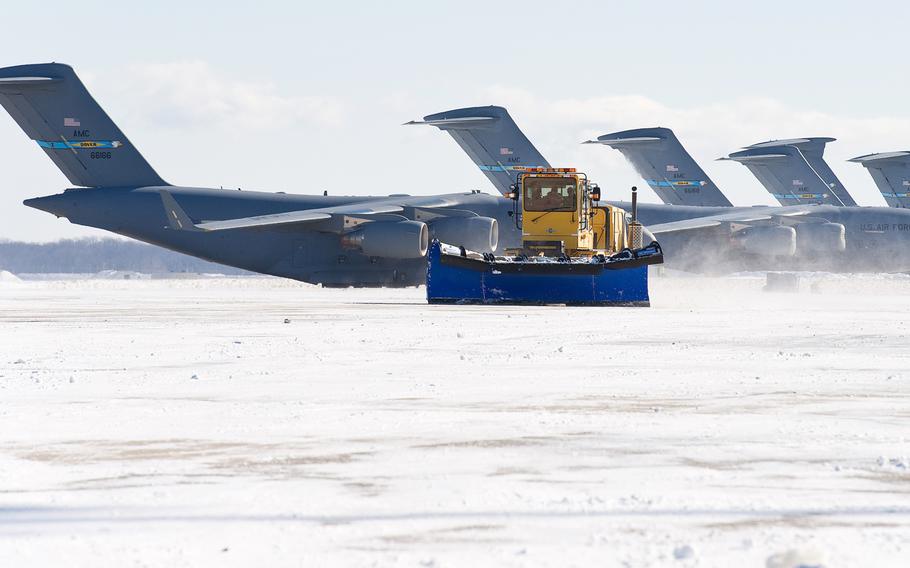 A snow plow from the 436th Civil Engineer Squadron clears snow from the flight line Jan. 22, 2014, at Dover Air Force Base, Del.