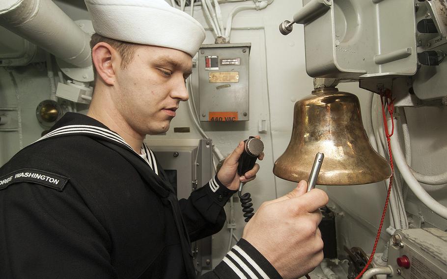 Petty Officer 3rd Class Christopher Landis, from Quincy, Ill., rings a bell over the main speaker circuit while standing petty officer of the watch aboard the aircraft carrier USS George Washington on Feb. 5, 2014.