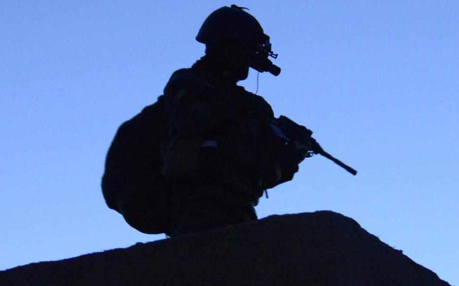 An Afghan National Army Special Forces commando attached to the 8th Special Operations Kandak stands over-watch in the village of Babus, Pul-E-Alam district, Logar province, Feb 16, 2014.