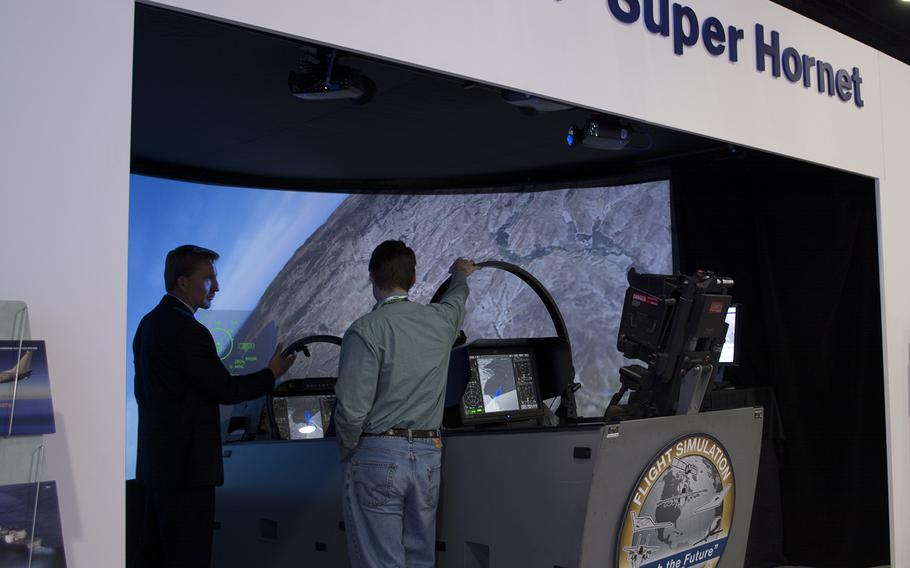 A Boeing exhibitor shows off a flight simulator for the F/A-18F Super Hornet. The simulator offered a large screen with very real looking graphics that flipped and turned with the Super Hornet. 