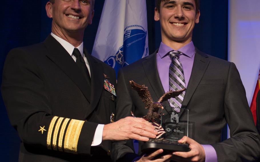 Ryan Patrick Curtin, representing the Navy, receives his Military Child of the Year award from Navy Adm. Jonathan Greenert on April 10, 2014. 